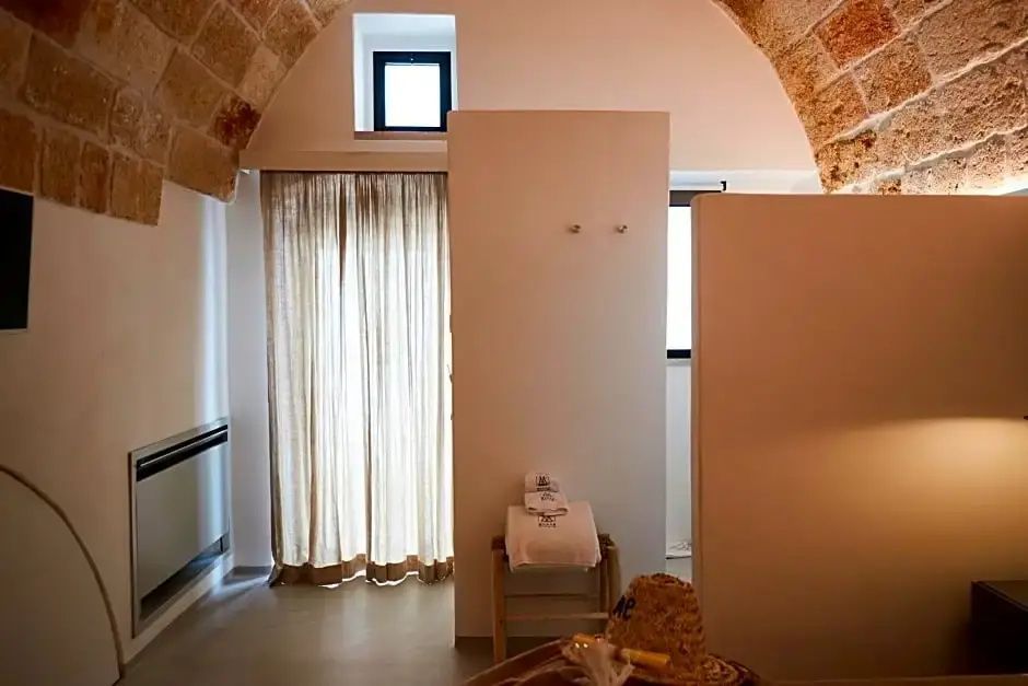 Zimmer mit historischer Gewölbedecke aus Naturstein, Vorhang und Raumteiler.