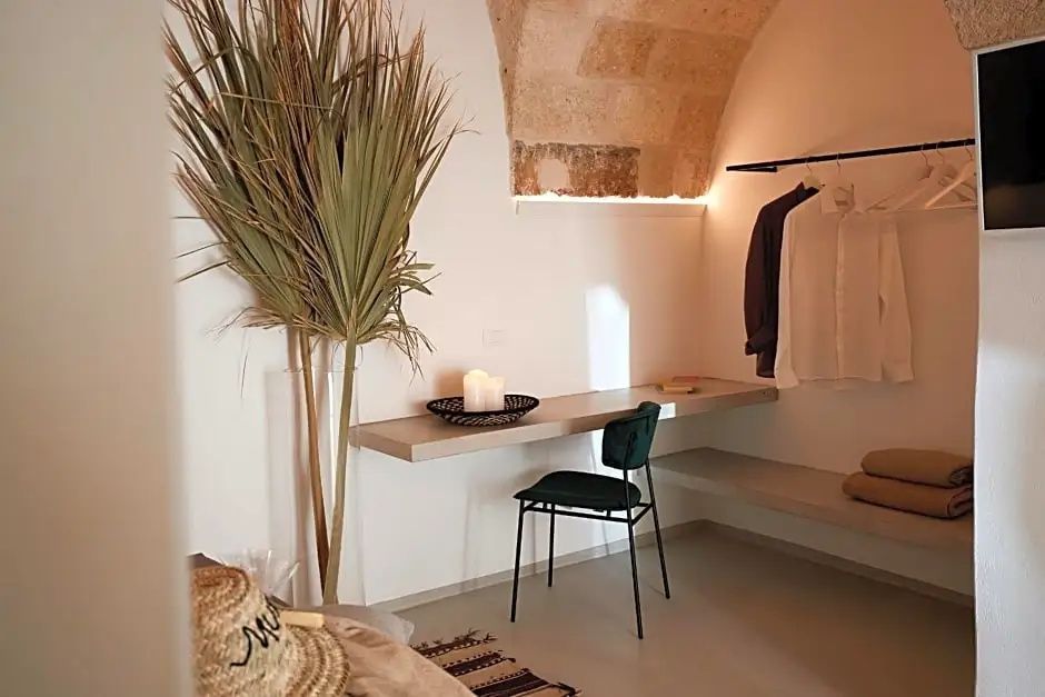 Schreibtisch mit grünem Stuhl unter einer beleuchteten Natursteindecke im Zimmer.