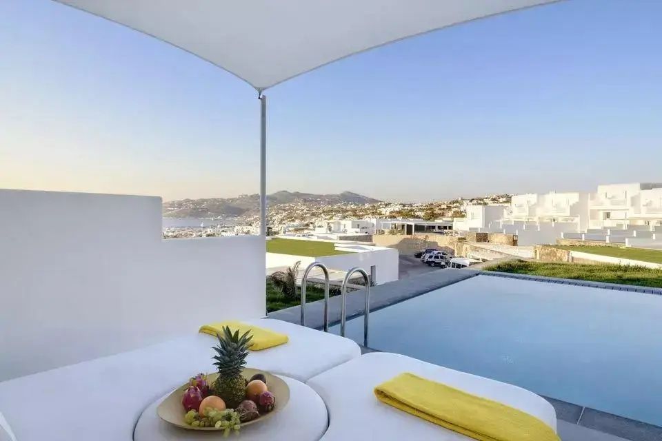 Terrasse mit privatem Pool, Sonnenliegen und Blick auf die Stadt und das Meer.