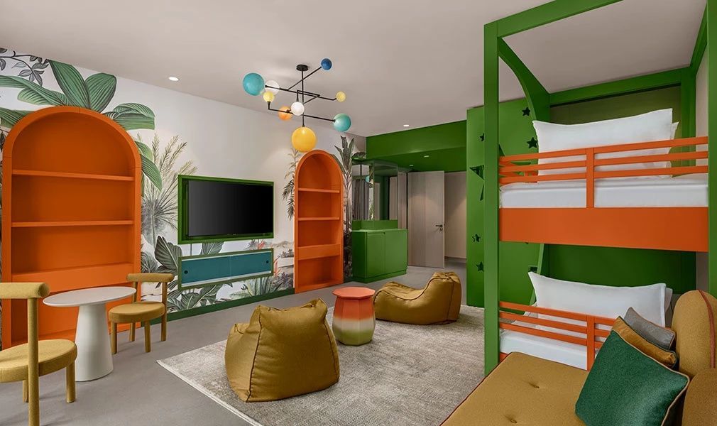Grünes Kinderzimmer mit Tropenmuster auf der Tapete, Etagenbett und Fernseher.
