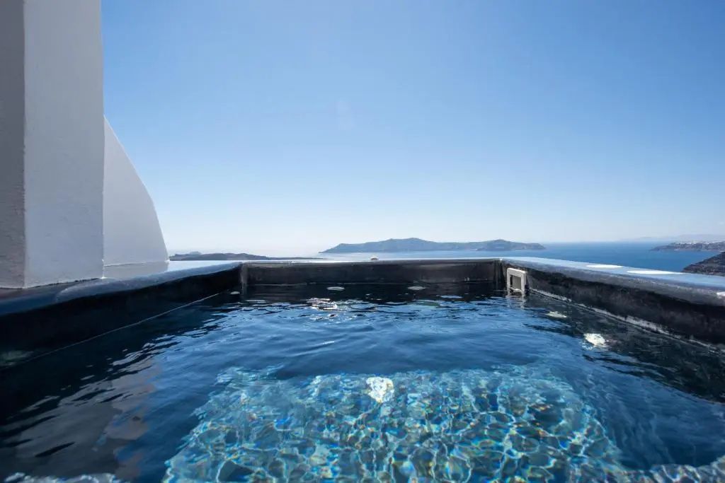 Ein sprudelnder Whirlpool im Außenbereich mit direktem Blick auf das blaue Meer.