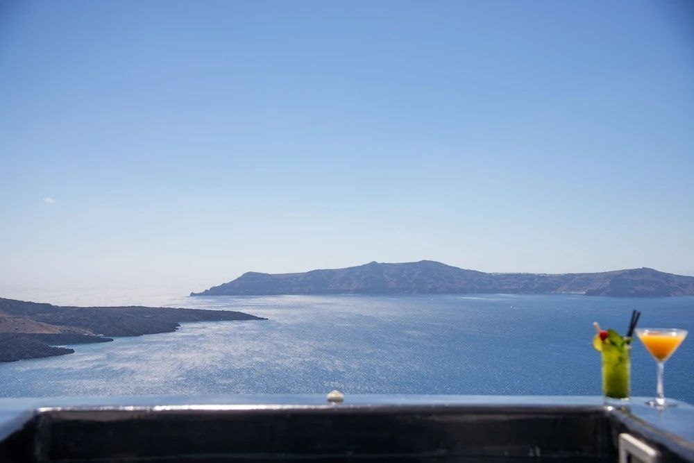 Weiter Blick über das blaue Meer und gebirgige Inseln bei sonnigem Himmel.