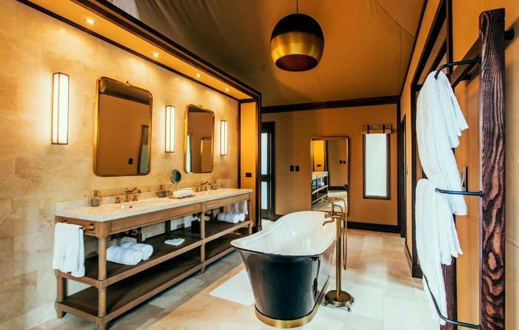 Freistehende schwarze Badewanne und Doppelwaschtisch im Badezimmer.