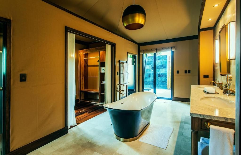 Geräumiges Badezimmer mit freistehender Badewanne und Zugang zum Ankleidebereich.