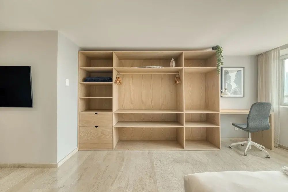 Großes offenes Holzregal mit Fächern und Schubladen im modern eingerichteten Zimmer.