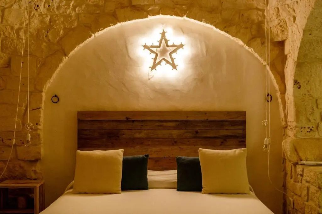 Das Bett hat ein Holzkopfteil und eine sternförmige Lampe an der Wandoberfläche.
