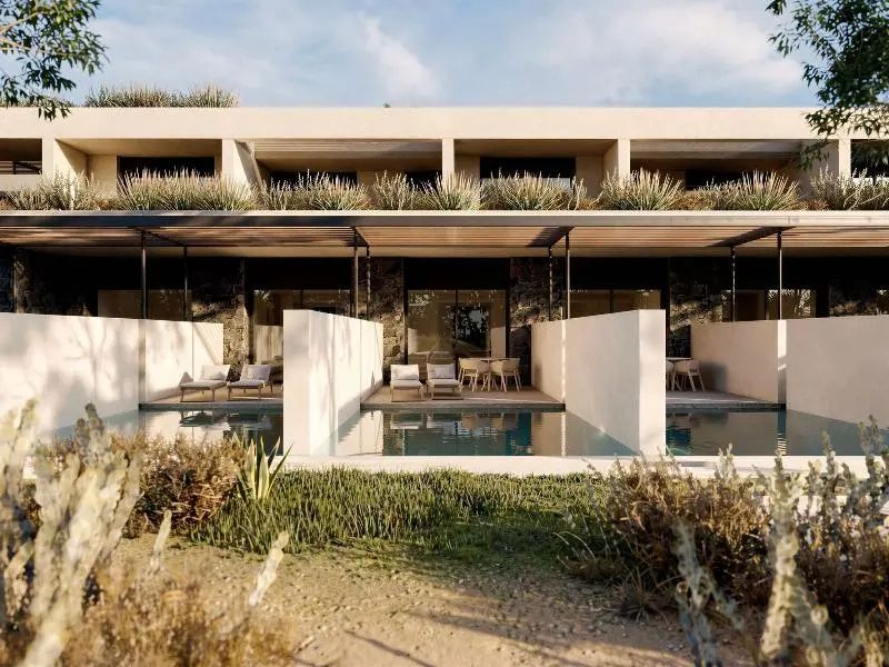 Außenansicht des Hotelgebäudes mit privaten Terrassenpools und bepflanzter Umgebung.