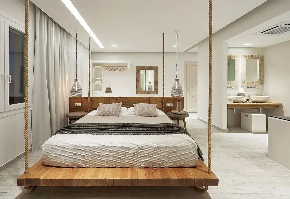 Helles Schlafzimmer mit Holzdoppelbett, hängenden Nachttischlampen und offener Gestaltung.