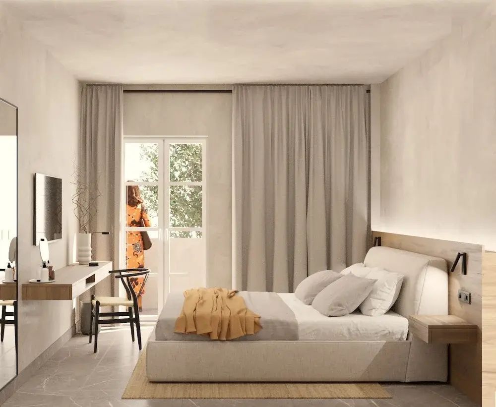 Heller Schlafbereich mit Doppelbett, einem Schreibtisch und Zugang zum Balkon.