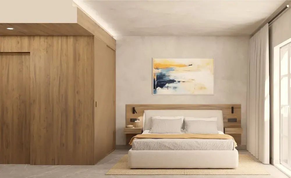 Doppelbett vor hellem Kopfteil aus Holz neben einem eingebauten Kleiderschrank.