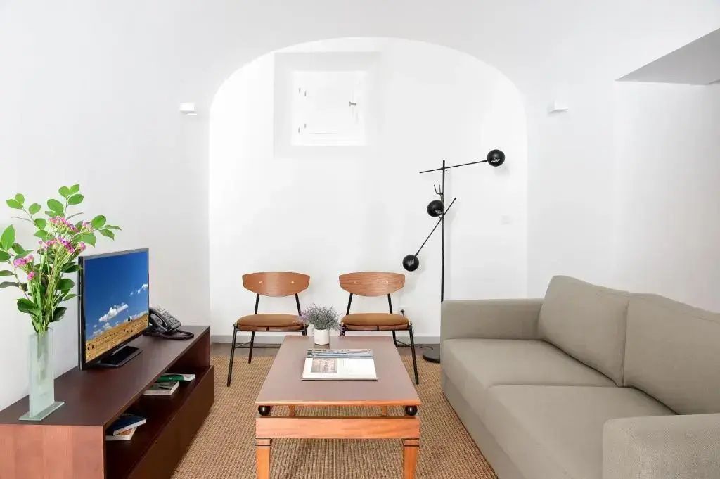 Modern eingerichteter Wohnbereich mit Sofa, Holztisch, Stühlen und Stehlampe.