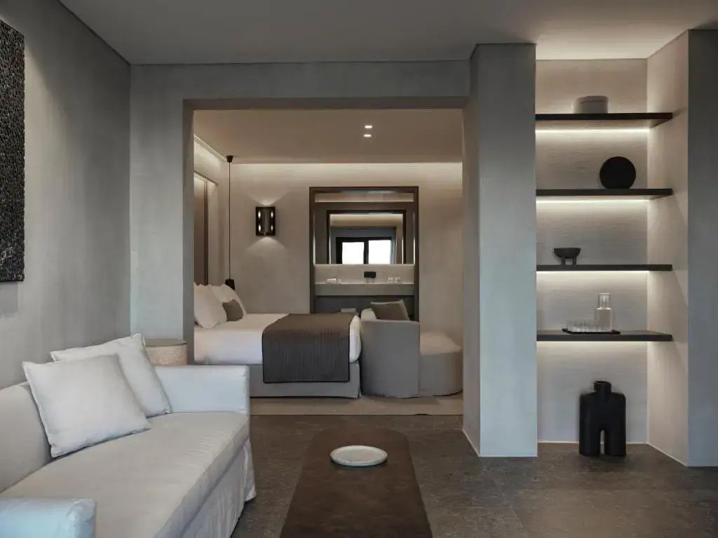 Wohnbereich mit hellem Sofa und Blick in das angrenzende Schlafzimmer.