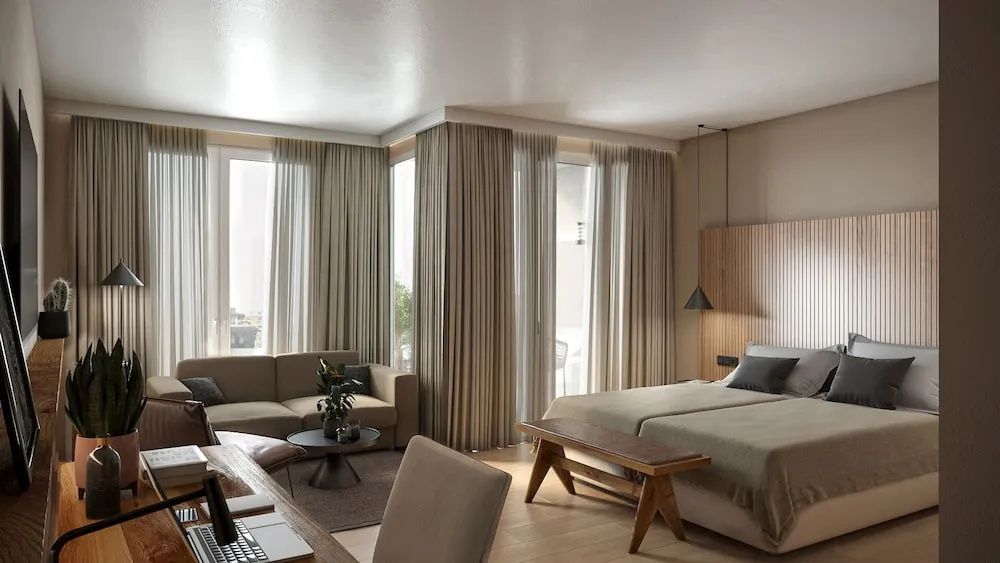 Geräumiges Hotelzimmer mit Doppelbett, Holzbank, Sofa und bodentiefen Fenstern mit Vorhängen.