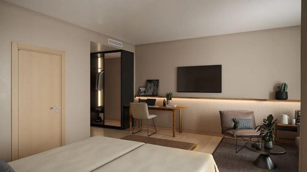 Arbeitsbereich im Zimmer mit Holzschreibtisch, Fernseher an der Wand und Einbauschrank.