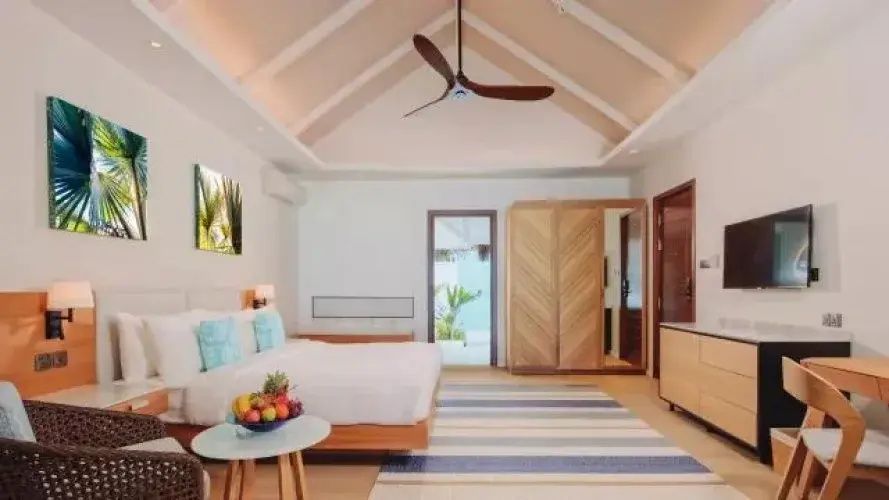 Schlafzimmer mit Holzdecke, Deckenventilator, großem Bett und Blick nach draußen.
