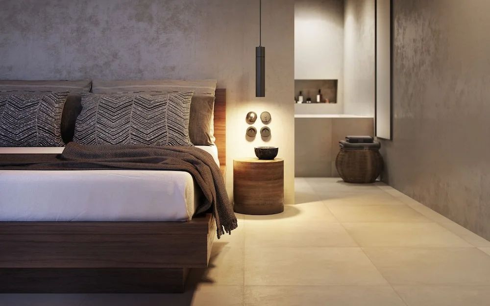 Modernes Hotelzimmer mit Holz-Doppelbett, Nachttisch und Blick ins offene Badezimmer.