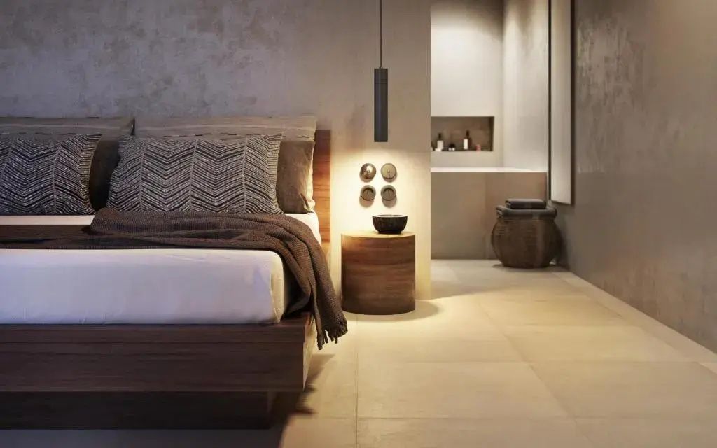 Blick vom Doppelbett auf den Nachttisch und den angrenzenden Badezimmerbereich.