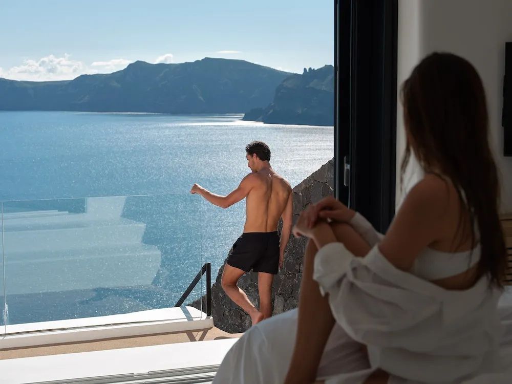 Blick von der Terrasse auf das blaue Meer und die gegenüberliegende Felsenküste.