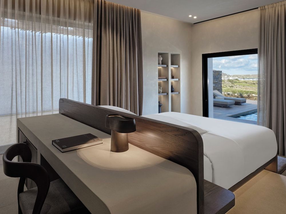 Helles Hotelzimmer mit Doppelbett, Schreibtisch und Zugang zur privaten Terrasse