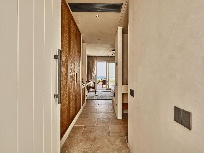 Eingangsbereich einer Hotel Suite mit Einbauschränken aus Holz und Blick ins Zimmer.