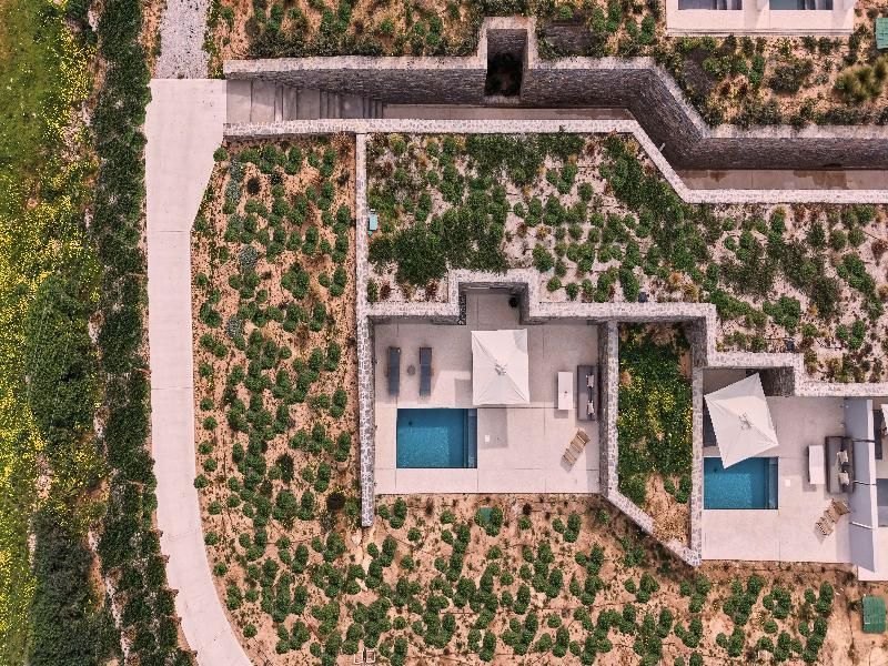 Vogelperspektive auf die in die Landschaft eingebetteten Terrassen mit Pools.