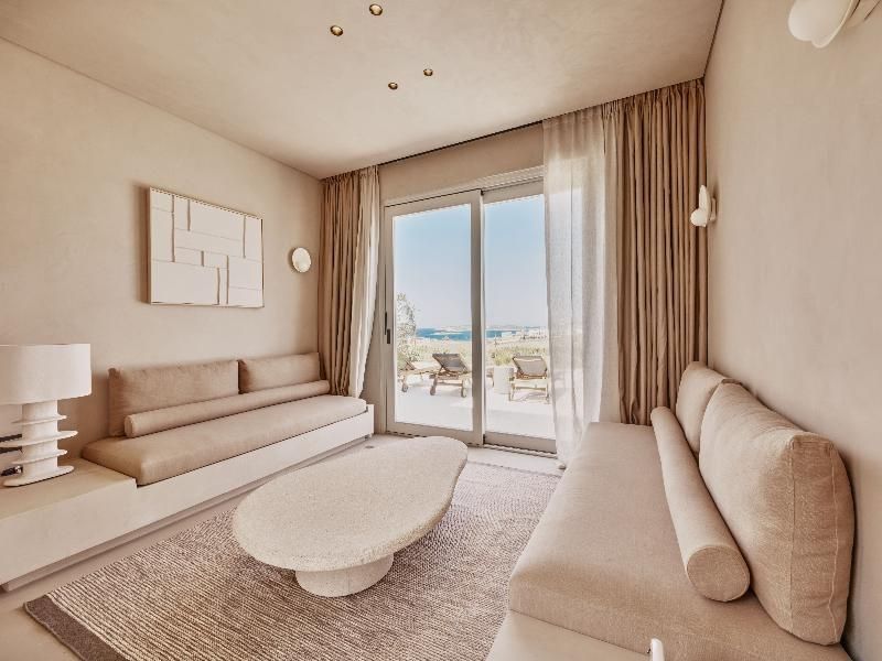 Helles Wohnzimmer in beigen Tönen mit zwei Sofas und Blick auf die Terrasse.