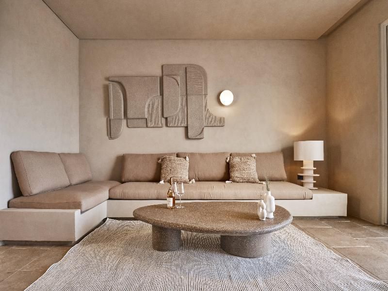 Modernes Wohnzimmer im erdigen Stil mit beigefarbener Eckcouch, Couchtisch und Wanddeko.