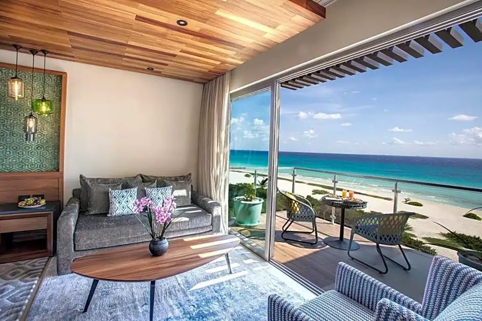 Blick aus der Suite durch die geöffnete Schiebetür auf Terrasse und Meer.