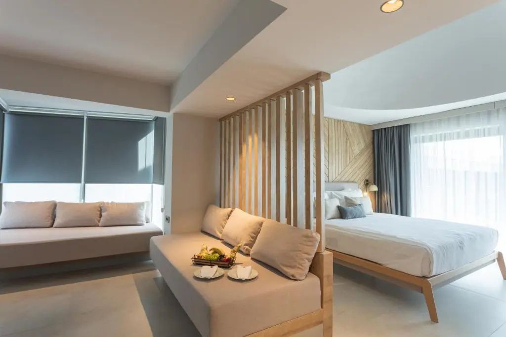 Sitzbereich einer Suite mit Sofa, Obstteller und Blick zum Doppelbett.