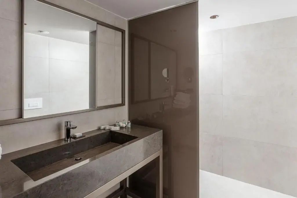 Modernes Badezimmer mit stehendem Waschtisch, Wandspiegel und Dusche.