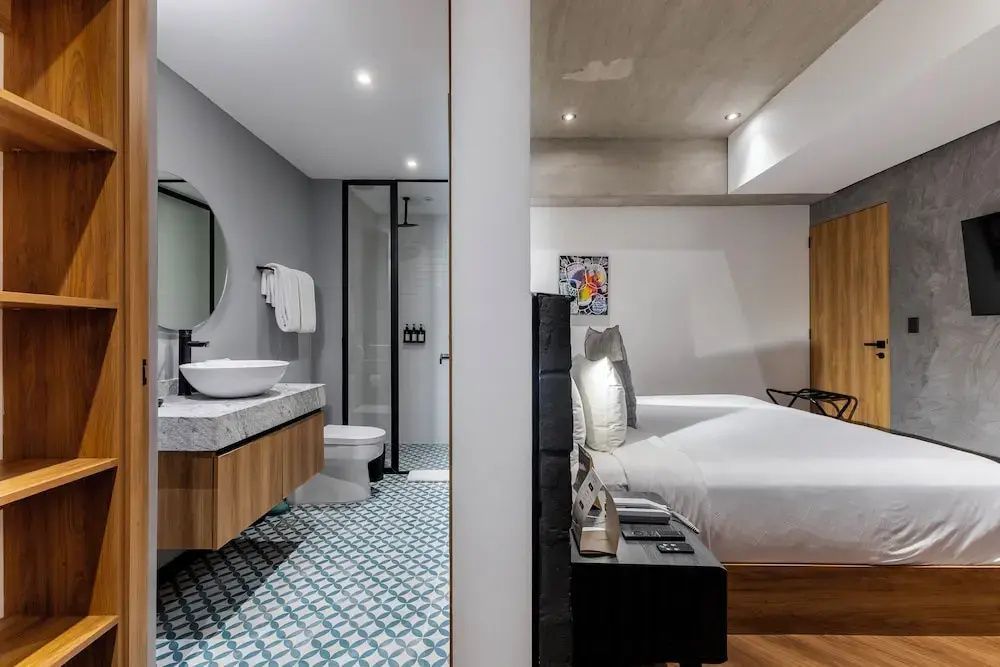Einblick in das Hotelzimmer mit offenem Übergang zum gefliesten Badezimmer.