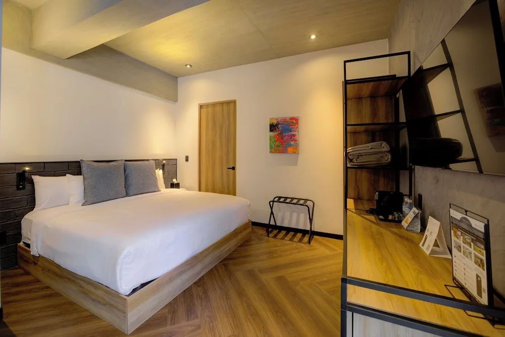 Modernes Hotelzimmer mit großem Doppelbett, Parkettboden und Holzmöbeln