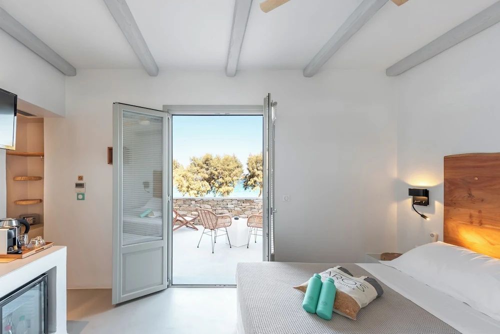 Blick aus dem Schlafzimmer durch die geöffnete Tür auf die Terrasse und das Meer.