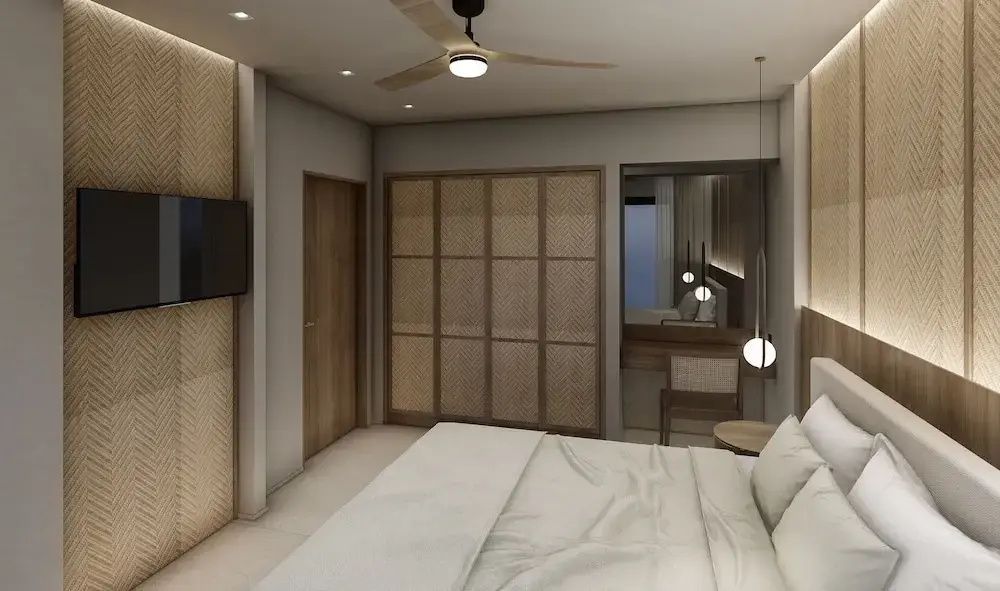Ein Schlafzimmer mit weiß bezogenem Bett, Holzschrank und Deckenventilator.