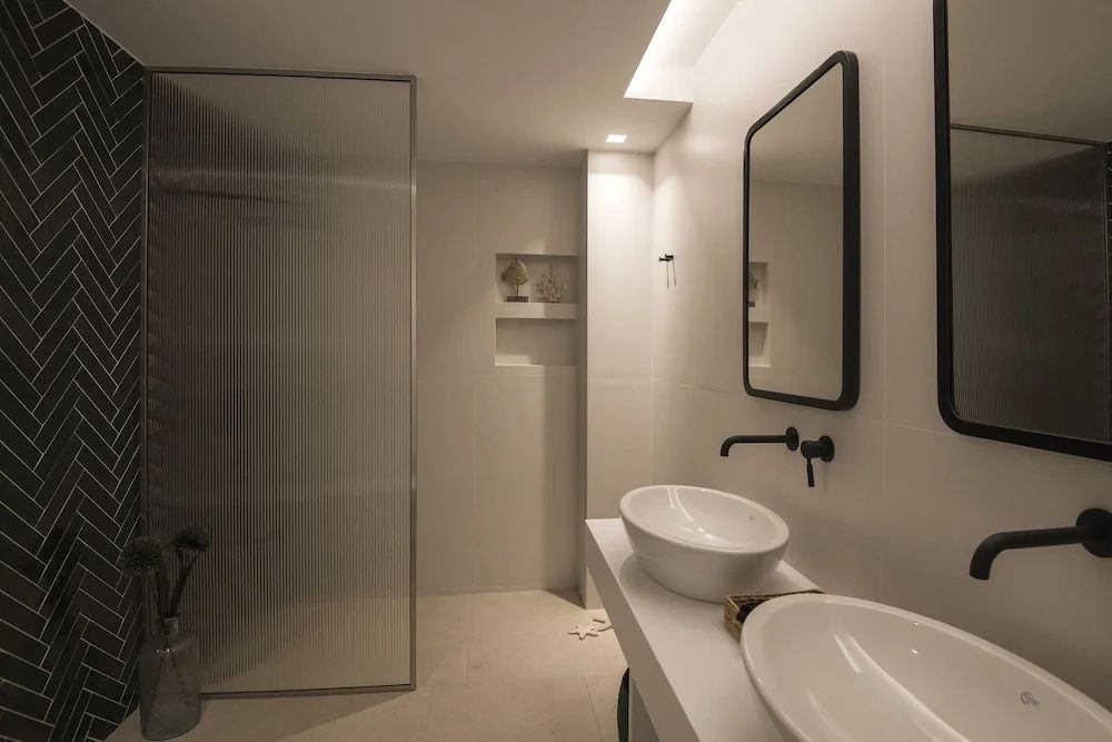 Modernes Badezimmer mit zwei Aufsatzwaschbecken und dunklen Armaturen