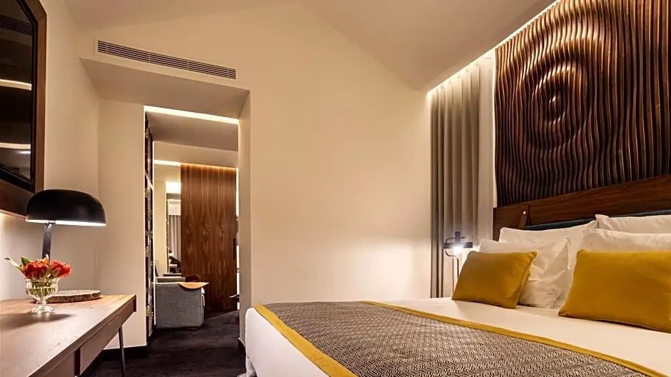 Blick auf das Bett und den Flurbereich in einem modern eingerichteten Zimmer.