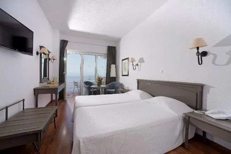 Geräumiges Doppelzimmer mit zwei Einzelbetten und Zugang zum Balkon.