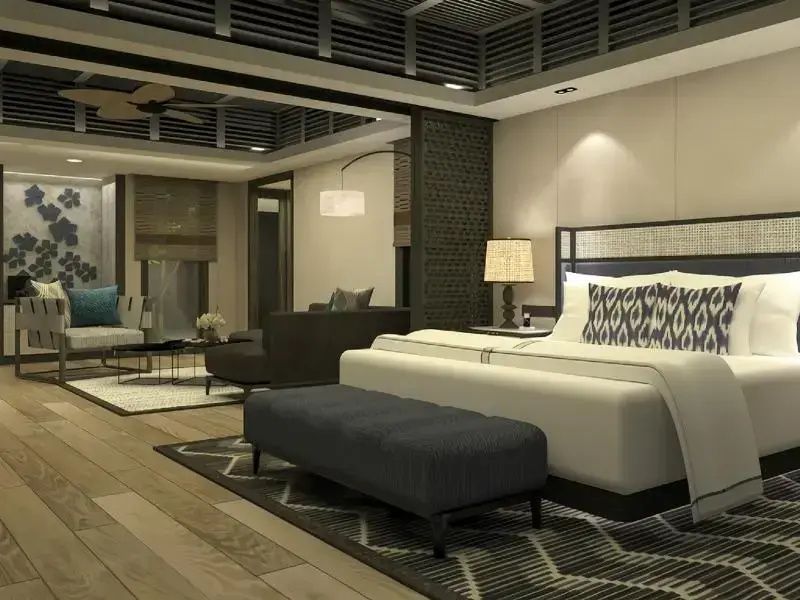 Großzügiges Hotelzimmer mit Doppelbett, Sitzbank und angrenzendem Wohnbereich.