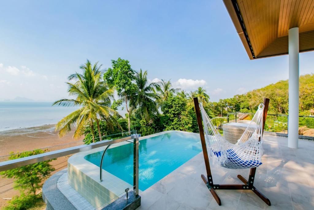 Terrasse mit privatem Pool, Hängematte und Weitblick auf Tropenvegetation und Meer.