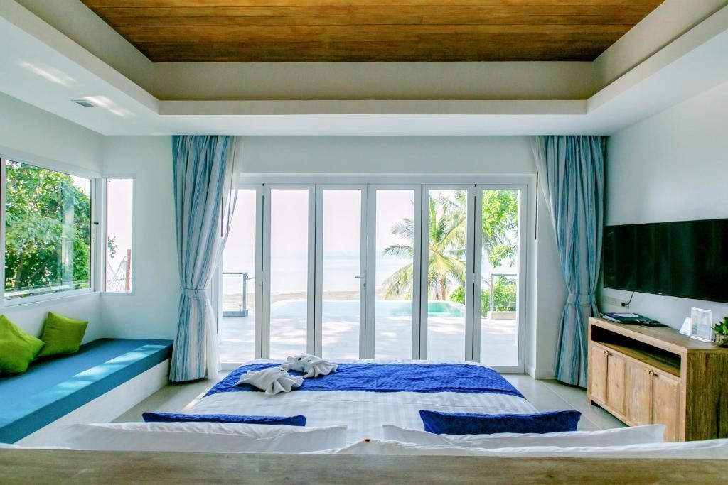 Blick durch das Schlafzimmer auf die bodentiefen Fenstertüren und die Terrasse.