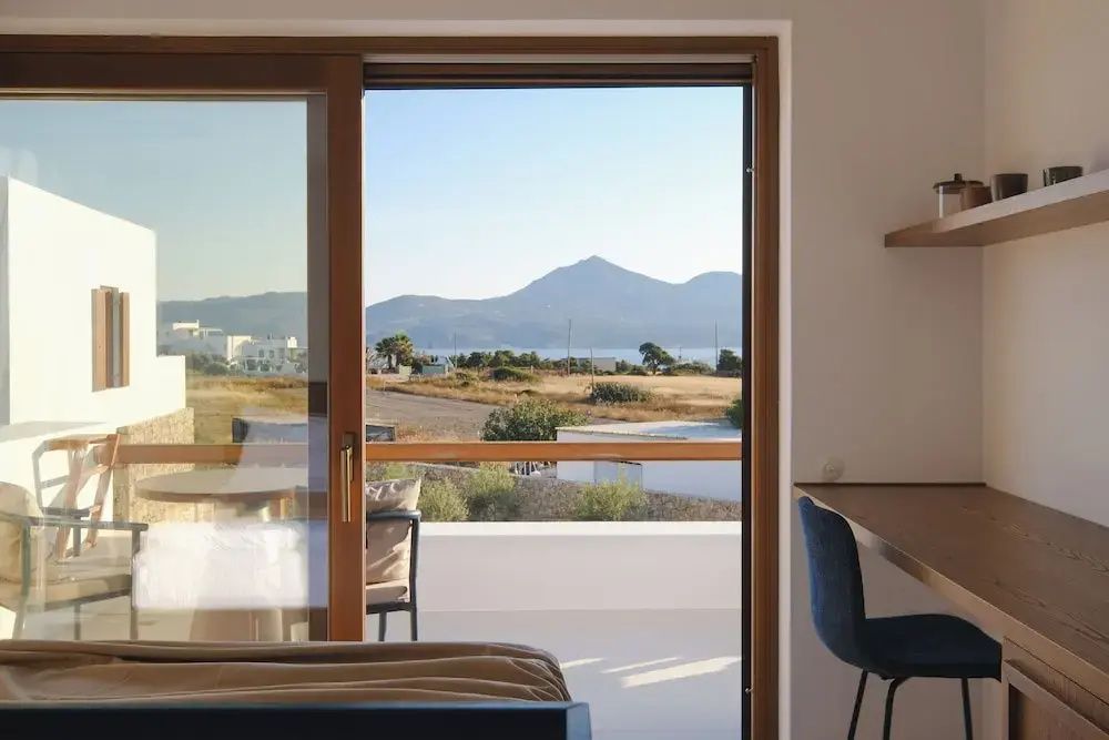 Blick aus dem Fenster über die Terrasse auf die umliegende Landschaft und Berge.