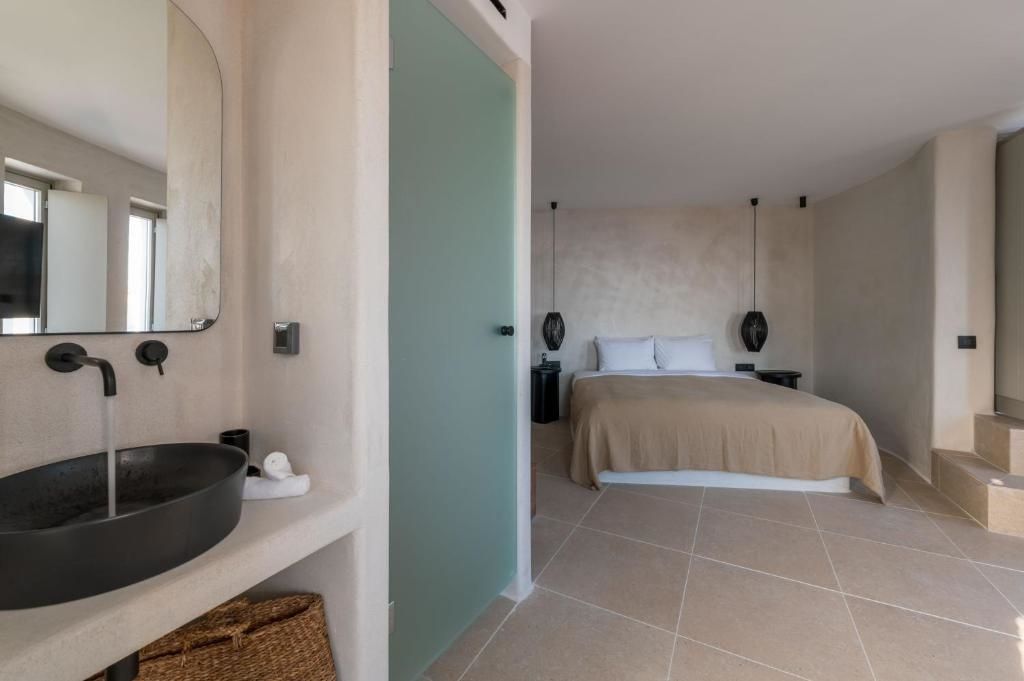 Modernes Hotelzimmer in hellen Tönen mit Doppelbett und integriertem Waschtisch.