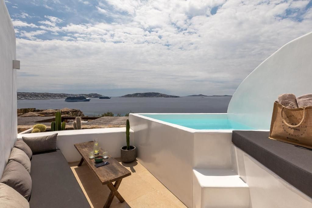 Terrasse mit privatem Pool, Holztisch und Weitblick auf das Meer und Schiffe.