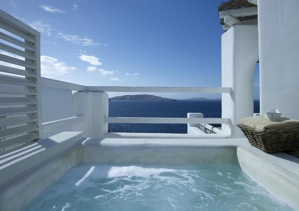 Whirlpool auf einem Balkon mit Ausblick auf das blaue Meer und Inseln.