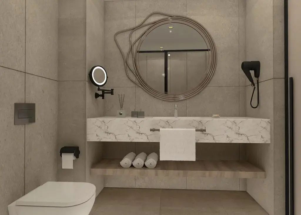 Badezimmer mit Marmorwaschtisch, rundem Spiegel und weißem Handtuch.