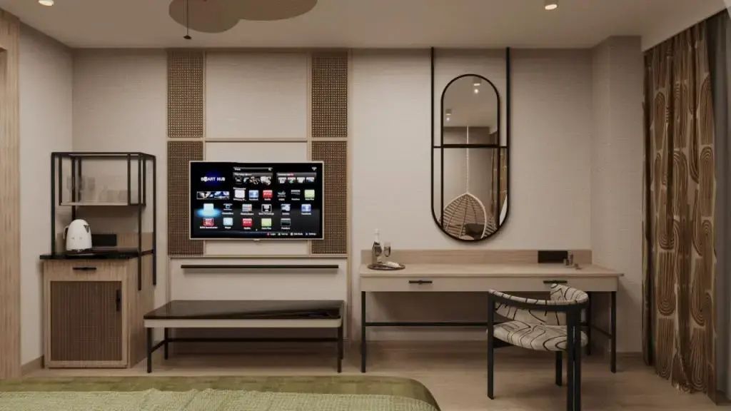 Schreibtisch mit ovalem Wandspiegel und Fernseher an einer hellem Wand.