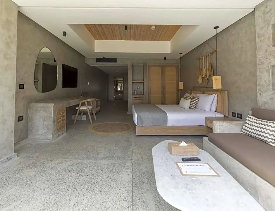 Moderner Hotelraum mit Doppelbett, Holzschreibtisch und grauen Wänden.