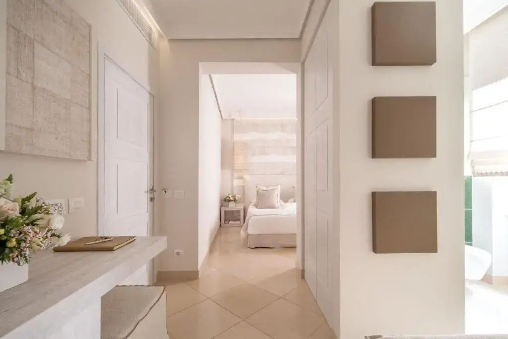 Heller Flur einer Hotel Suite mit Blick auf das Doppelbett im angrenzenden Schlafbereich.