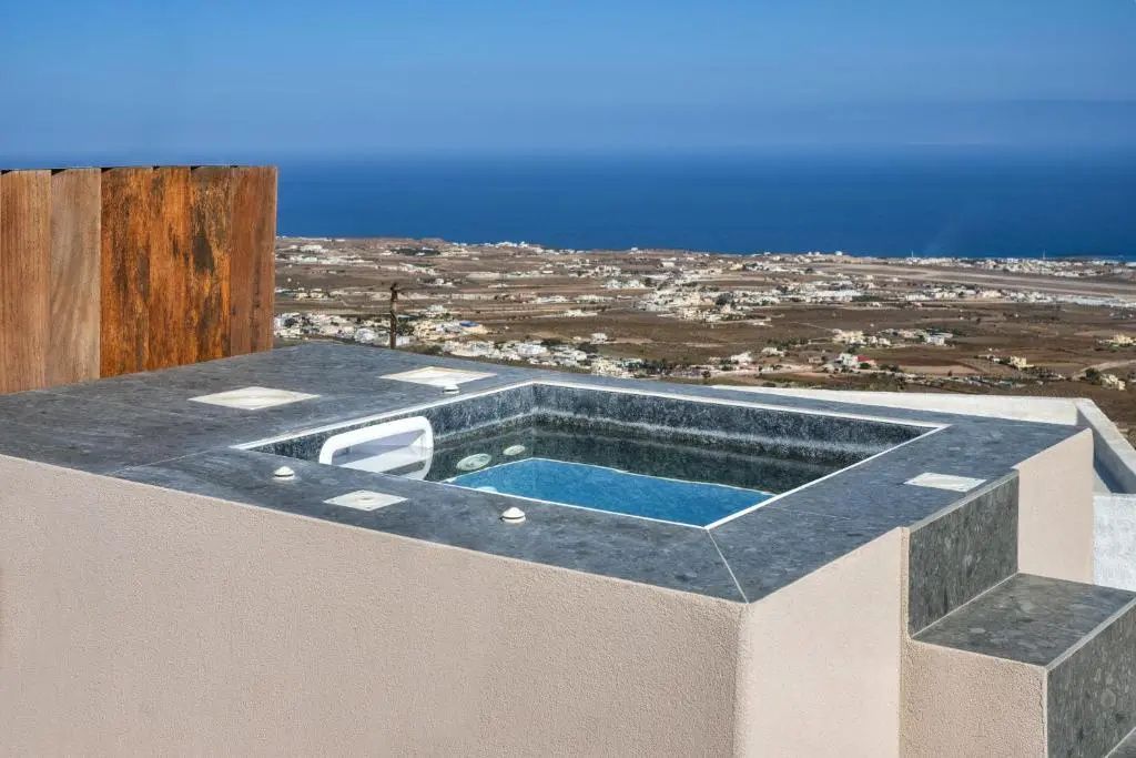 Whirlpool auf einer Terrasse mit Blick über die Insellandschaft und das blaue Meer.