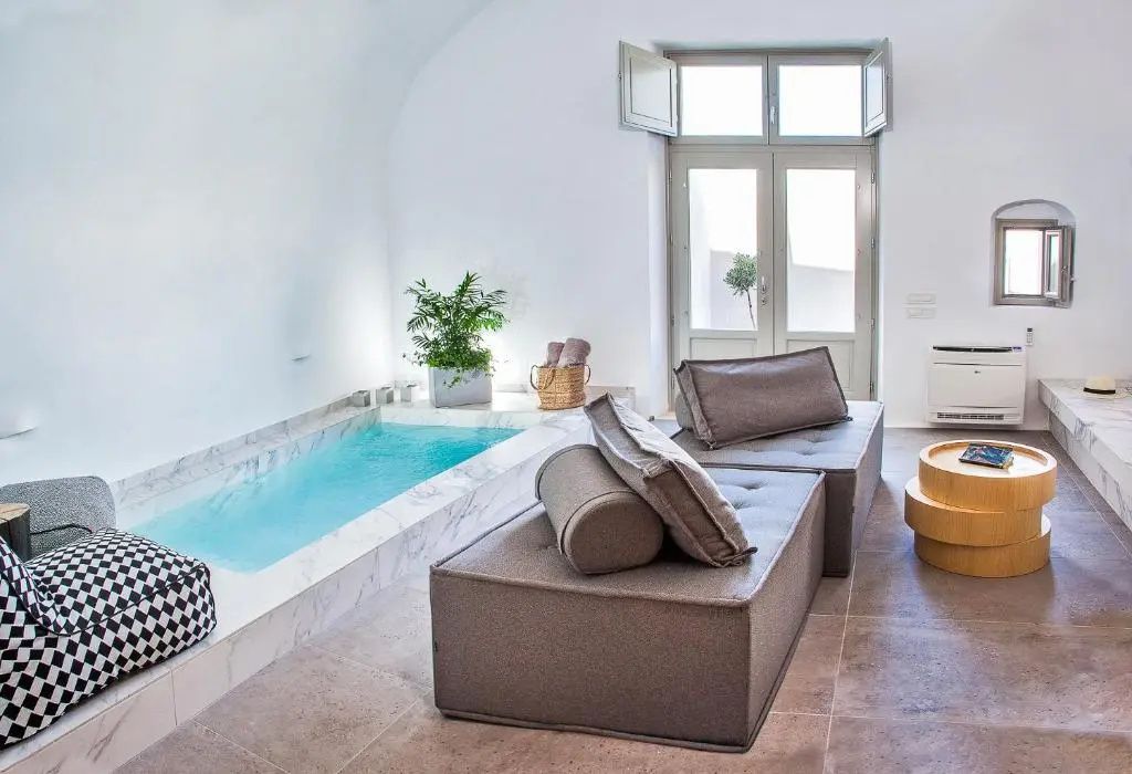 Innenbereich einer Suite mit integriertem Pool und grauen Sitzpolstern.